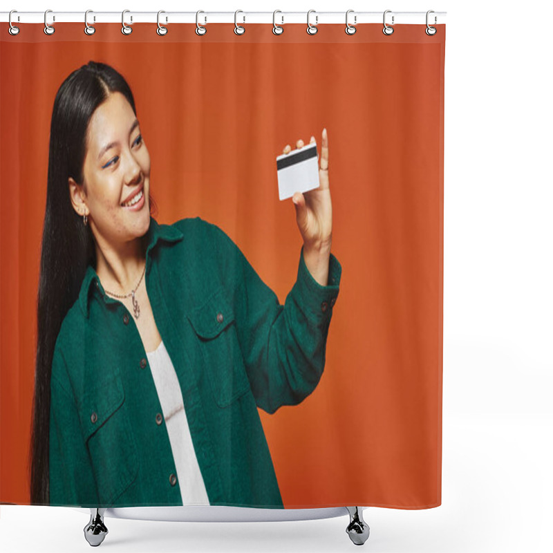 Personality  Happy Young Asian Woman In Green Jacket Looking At Credit Card On Orange Background, Consumerism Shower Curtains