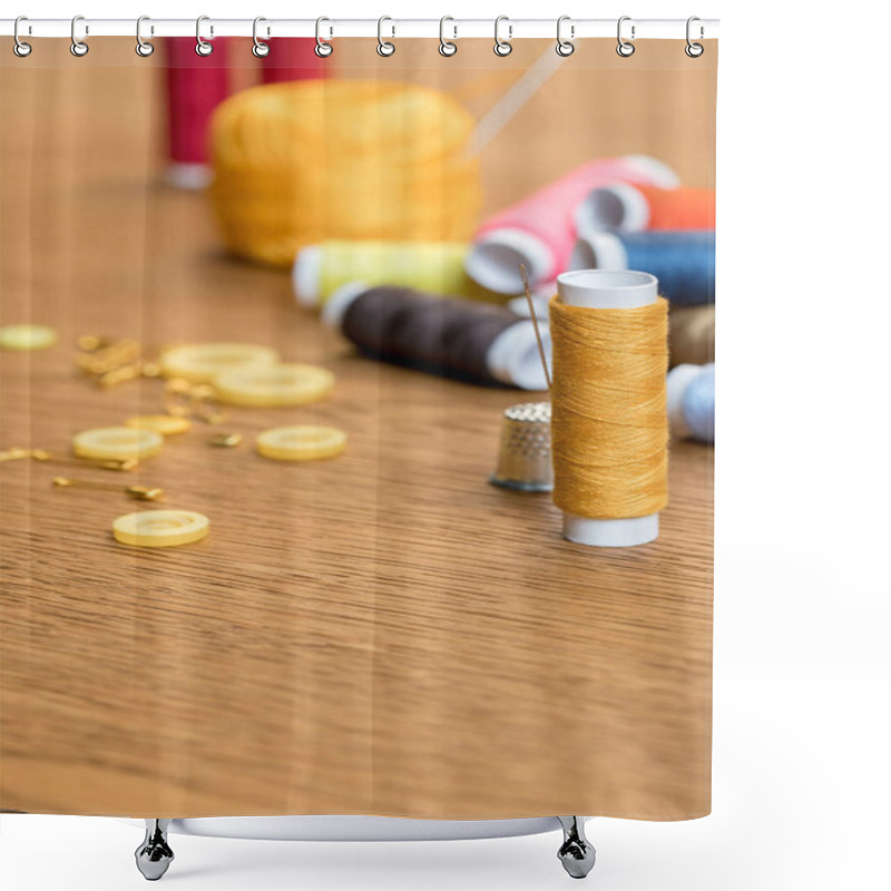 Personality  selective focus of thimble and yellow thread coil with needle on wooden table with copy space shower curtains