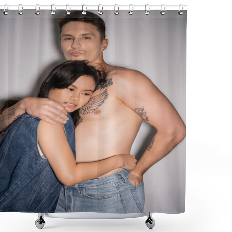 Personality  Tattooed And Muscular Man Pouting Lips And Hugging Asian Woman In Denim Vest On Grey Background Shower Curtains