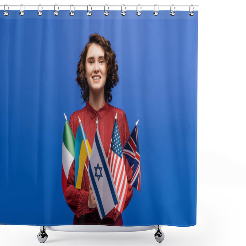 Personality  Pleased Woman Smiling At Camera While Holding Flags Of Different Countries Isolated On Blue Shower Curtains