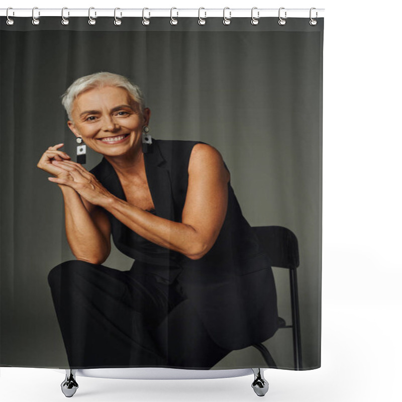 Personality  Charming And Happy Senior Lady In Black Classic Attire Looking At Camera And Posing On Chair On Grey Shower Curtains