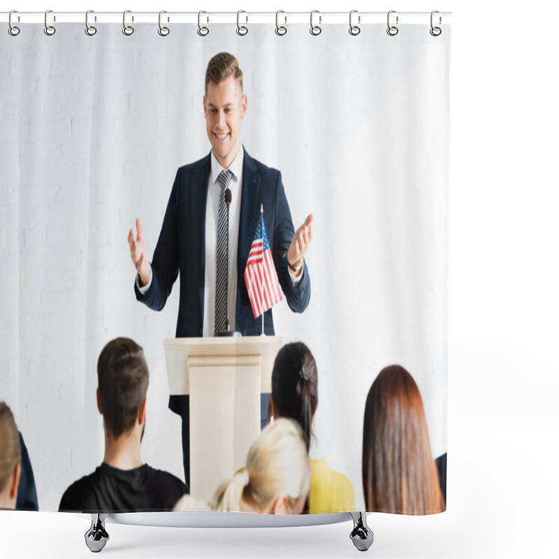 Personality  Smiling Speaker Standing With Open Arms In Front Of Voters In Conference Hall, Blurred Foreground Shower Curtains