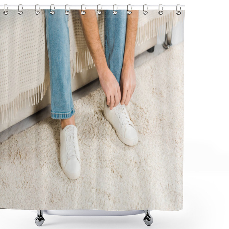 Personality  Cropped View Of Man In Jeans Sitting And Tying Shoelaces On Sneakers At Home Shower Curtains