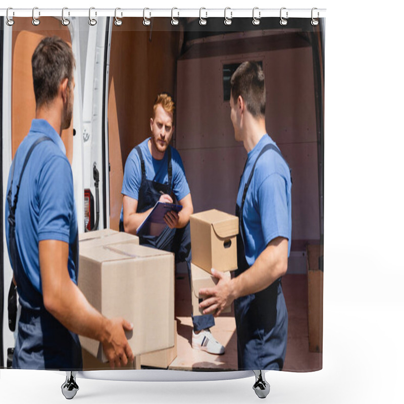 Personality  Selective Focus Of Loader Writing On Clipboard Near Colleagues Holding Carton Packages Outdoors Shower Curtains