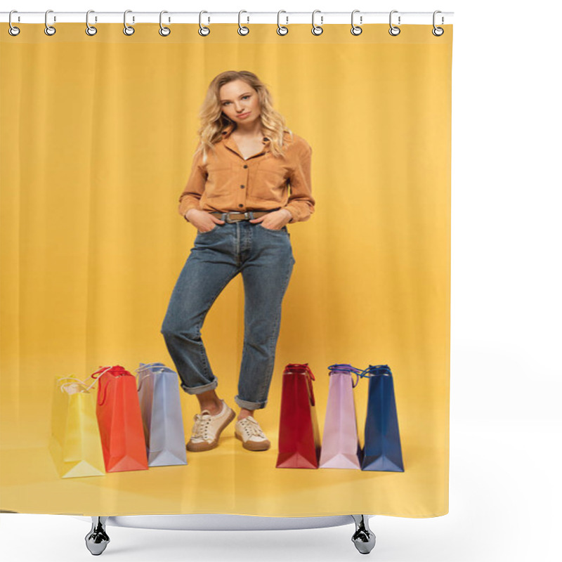 Personality  Blonde Woman With Hands In Pockets Beside Shopping Bags On Floor On Yellow Background Shower Curtains