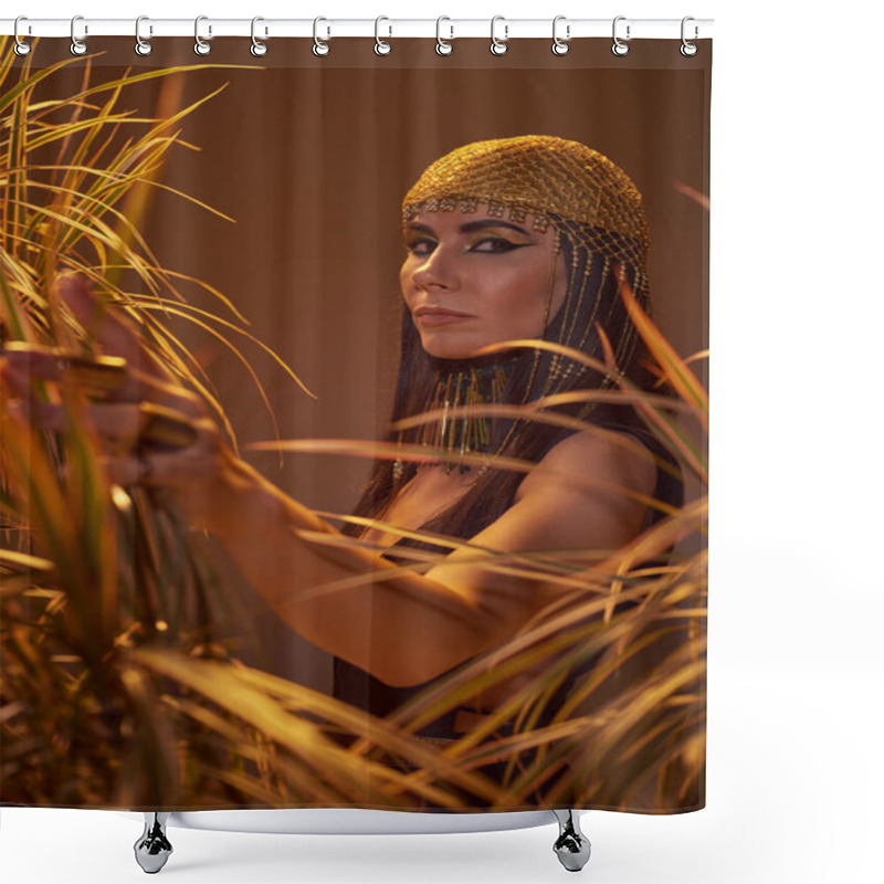 Personality  Stylish Brunette Woman In Egyptian Look Touching Plants And Looking At Camera Isolated On Brown Shower Curtains