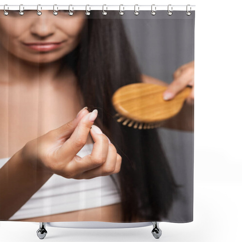 Personality  selective focus of brunette woman holding lost hair while brushing isolated on black shower curtains