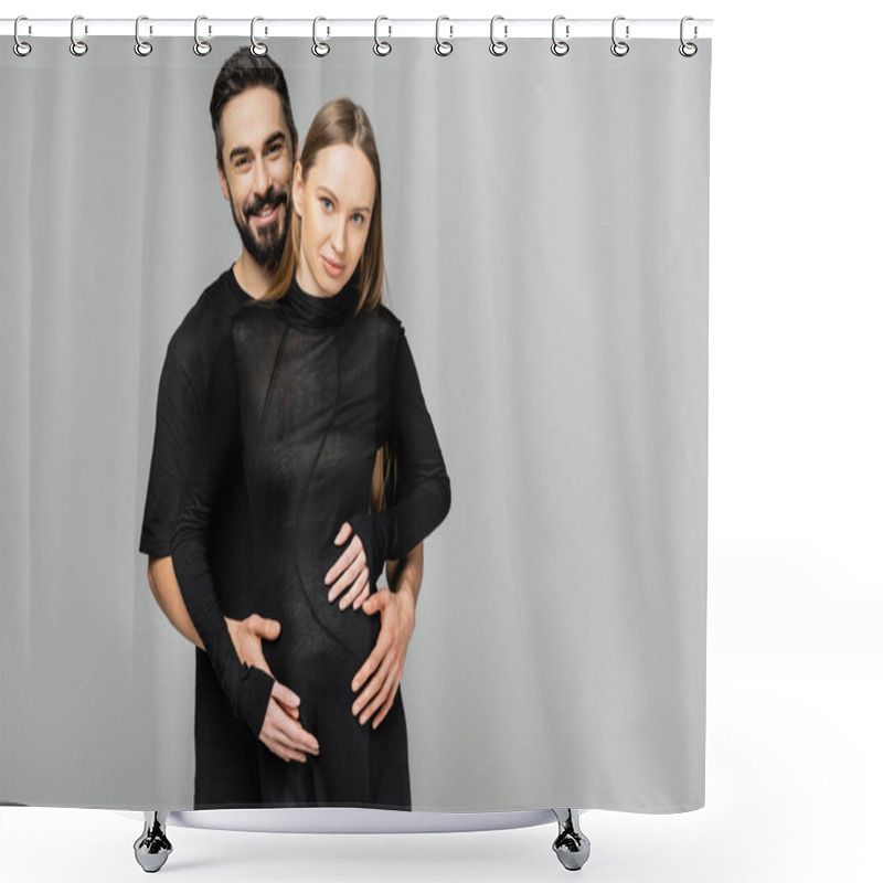 Personality  Positive And Bearded Man In Black T-shirt Hugging Fashionable And Pregnant Wife In Black Dress And Looking At Camera While Standing Isolated On Grey, Concept Of Birth Of Child Shower Curtains