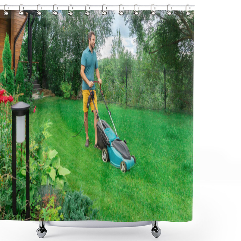 Personality  A Man In A Good Mood Mows The Grass With An Electric Lawn Mower In The Garden. The Hardworking Owner Takes Care Of The Lawn On A Sunny Summer Day. Shower Curtains