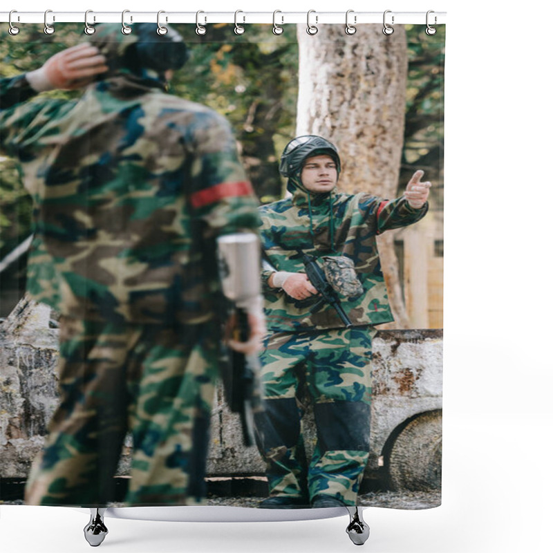 Personality  Selective Focus Of Male Paintballer In Camouflage Uniform Holding Marker Gun And Pointing By Hand To His Team Near Broken Car Outdoors  Shower Curtains