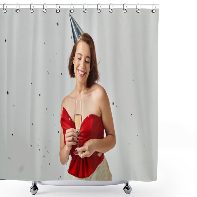 Personality  Merry Christmas, Positive Young Woman In Party Cap Holding Glass Of Champagne Near Confetti On Grey Shower Curtains