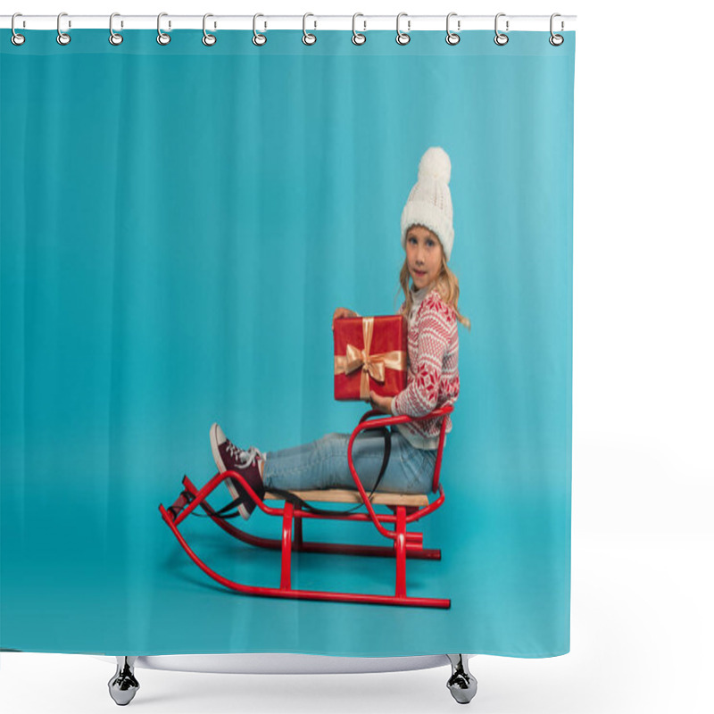 Personality  Girl In Knitted Hat And Jumper Holding Red Gift Box While Sitting In Sled On Blue Shower Curtains