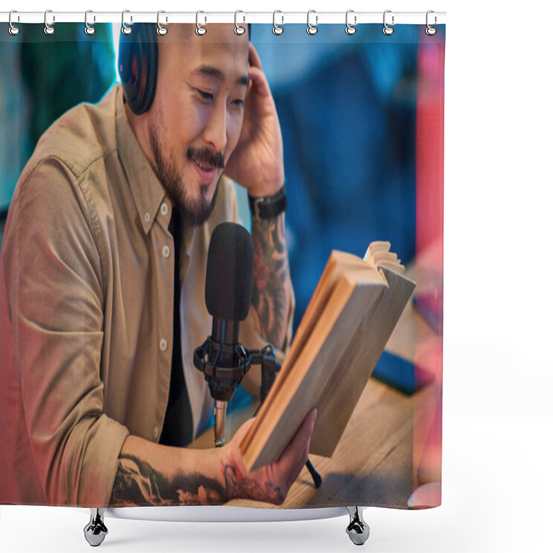 Personality  An Asian Man Sits At A Desk In His Home Studio, Wearing Headphones And Holding A Book While Recording A Podcast. Shower Curtains