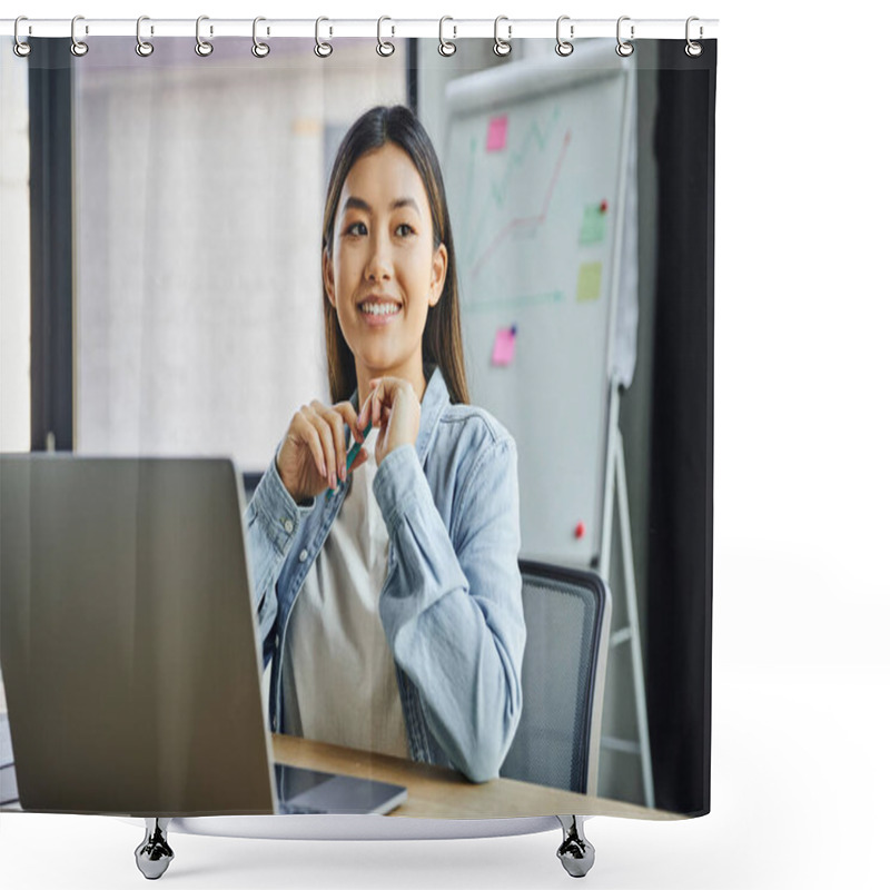 Personality  Cheerful And Dreamy Asian Businesswoman In Blue Denim Shirt Sitting In Front Of Notebook, Holding Pen And Looking Away Near Flip Chart On Blurred Background In Modern Office  Shower Curtains