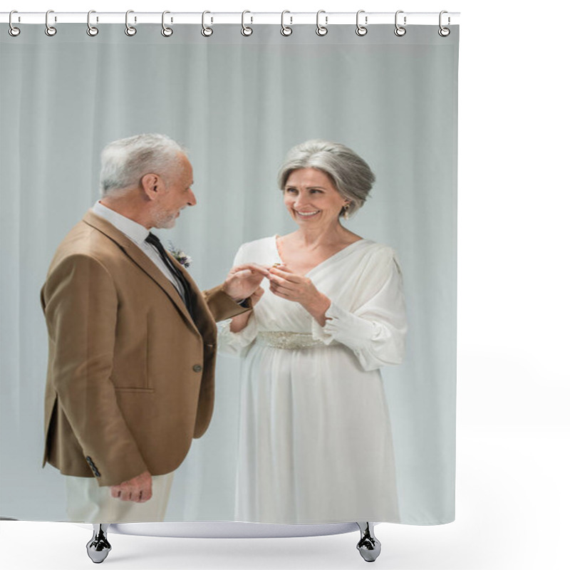 Personality  Cheerful Mature Bride In White Dress Wearing Golden Engagement Ring On Finger Of Middle Aged Groom Isolated On Grey Shower Curtains