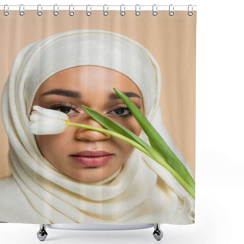 Personality  Portrait Of Pretty Muslim Woman In Hijab Looking At Camera Through Tulip Isolated On Beige Shower Curtains