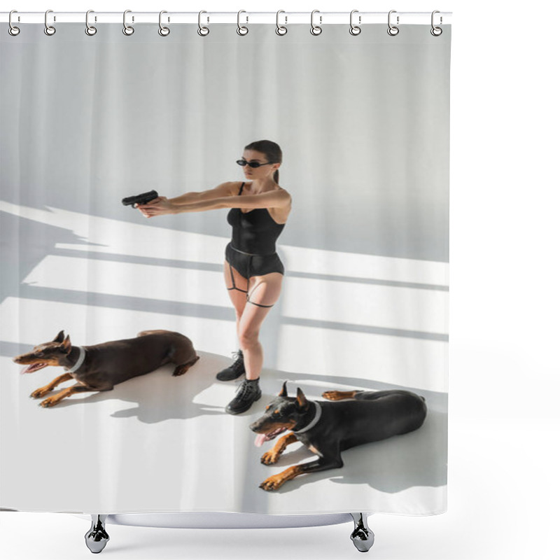 Personality  Sexy Woman In Bodysuit Aiming With Gun Near Dobermans On Grey Background With Shadows Shower Curtains