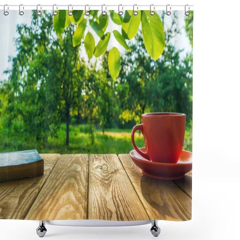 Personality  Orange Cup Of Hot Coffee And A Book On A Wooden Table In A Green Garden In The Morning. Summer Background. Shower Curtains