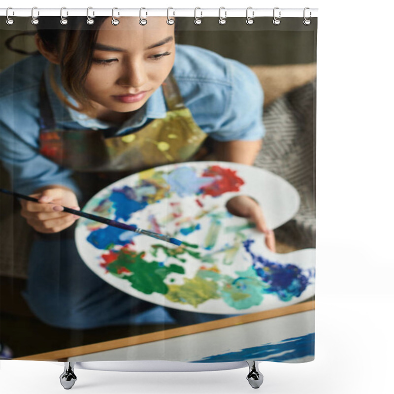 Personality  A Young Asian Woman In An Apron Holds A Palette Of Paints, Concentrating On Her Art In A Workshop. Shower Curtains