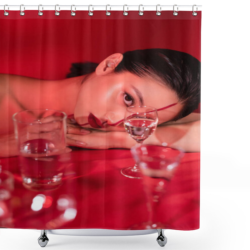 Personality  Brunette Asian Woman With Artistic Makeup Lying And Looking At Camera Near Blurred Glasses On Red Background Shower Curtains